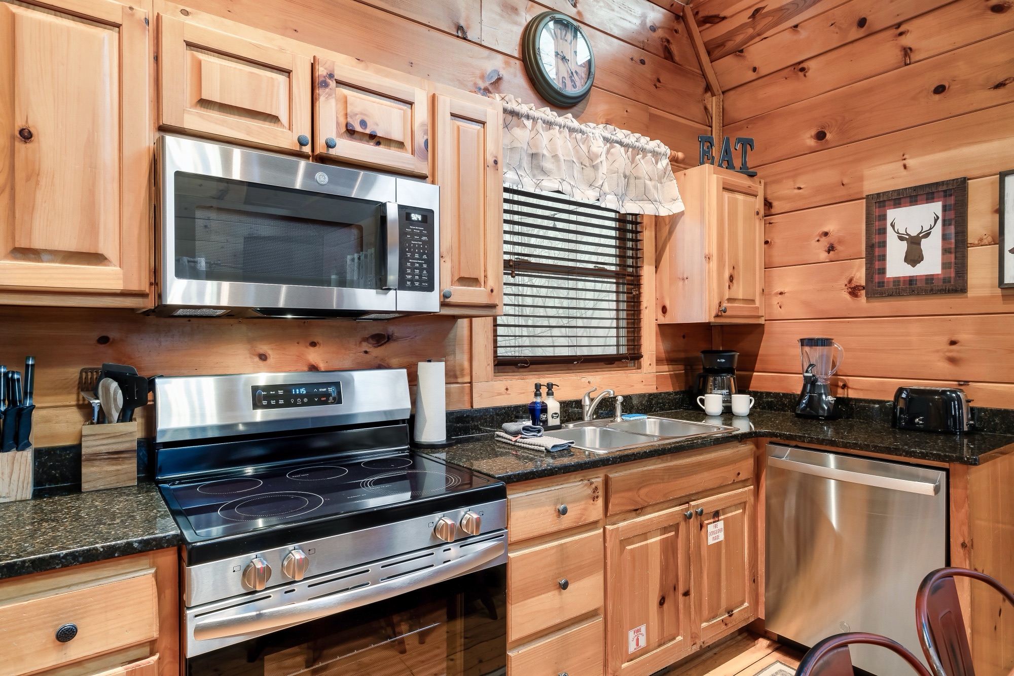 Bearadise kitchen with stainless steel appliances, granite counters, and a rustic EAT sign